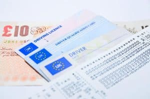 Mehrere europäische Führerscheine und Dokumente liegen gestapelt auf einem weißen Hintergrund.