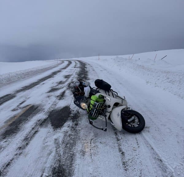 schneebedeckte Straßen-Kurve mit seitlich liegender Vespa