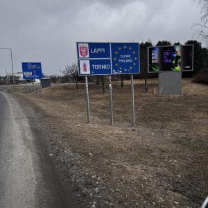 Straße mit Grenzschildern zwischen Polen und der Slowakei, bewölkter Himmel, keine Autos in unmittelbarer Nähe.