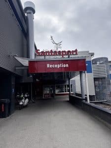 Eingang zum Santapark mit rotem Schild „Reception“ und Rentierfigur oben auf dem Dach.