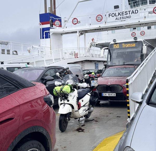 Mehrere Autos und ein Roller stehen dicht beieinander auf einer Autofähre mit dem Namen „Folkestad“.