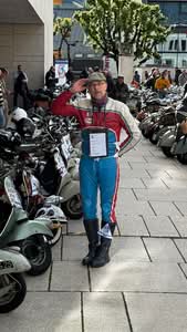 Marco in historischer Lederkombi von Esso vor den Faro Basso Modellen in Vorbereitung auf den Start.